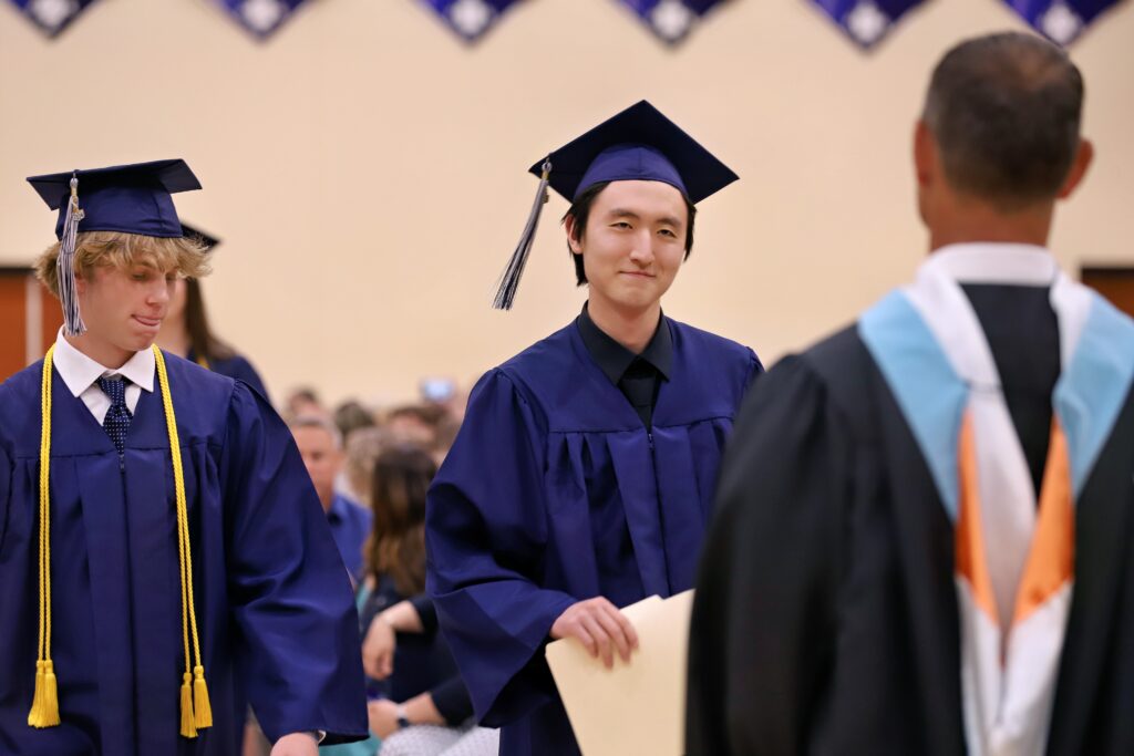 Student in cap and gown holding diploma